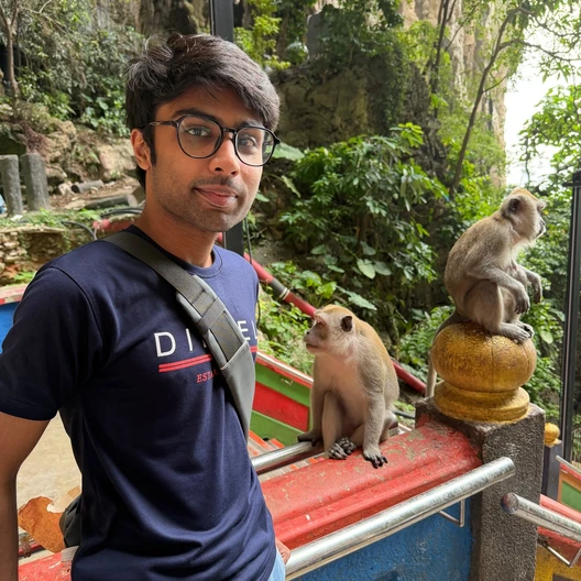 Muhammad Mahad beside monkeys during a trip to Southeast Asia