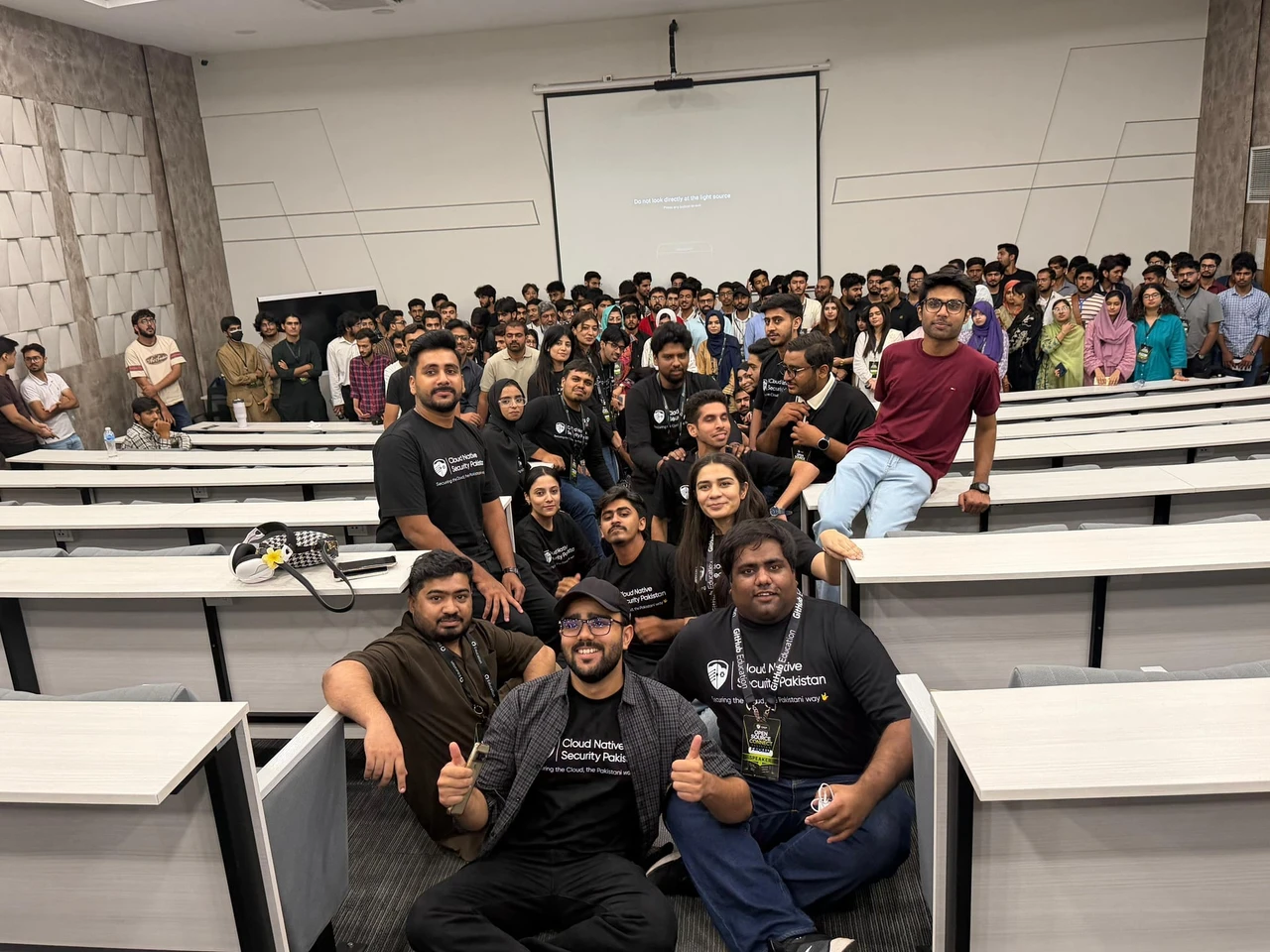 Attendees and organizers gather for a group photo in the lecture hall