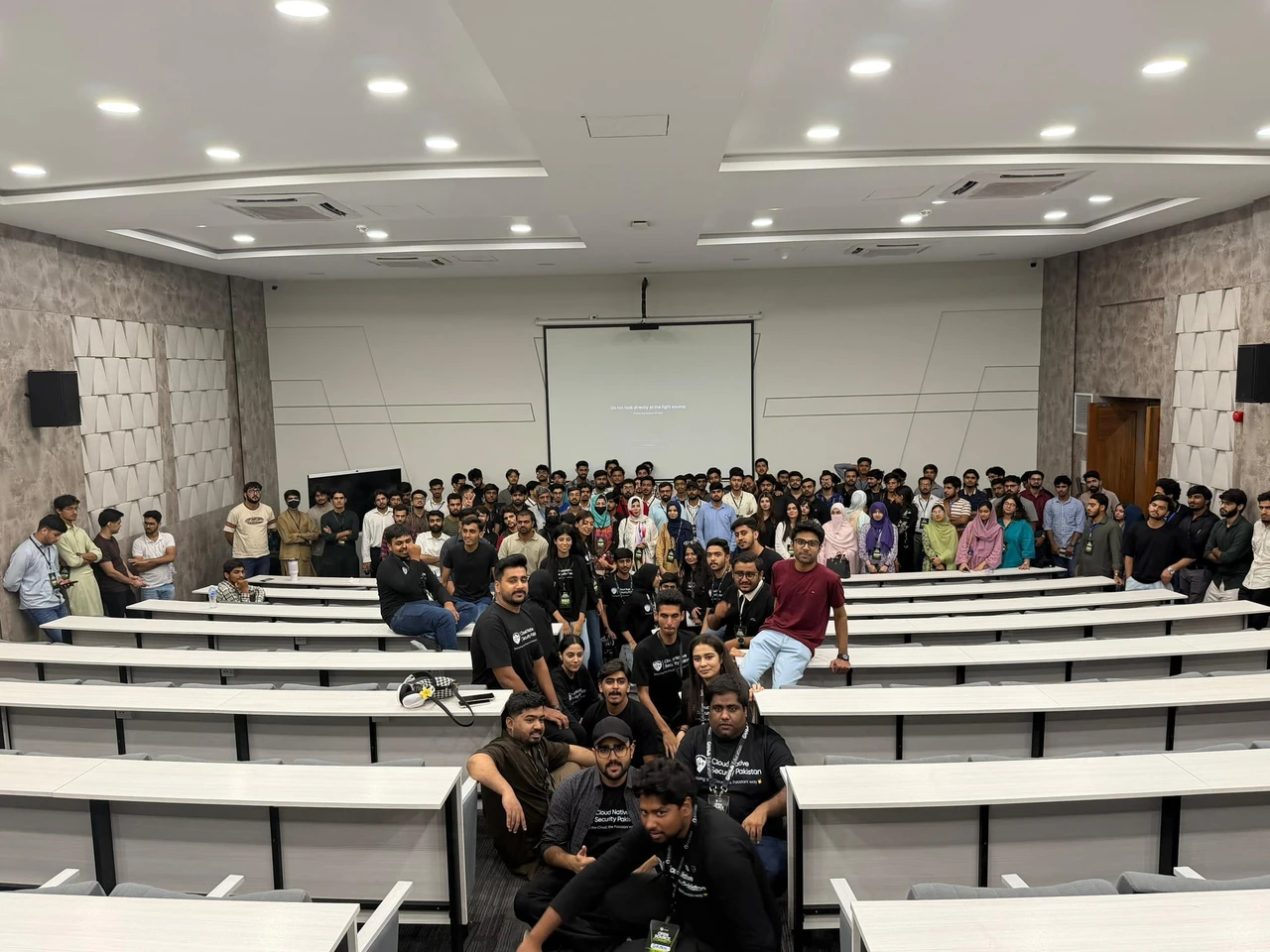 Wide view of the community group gathered inside the tiered lecture hall