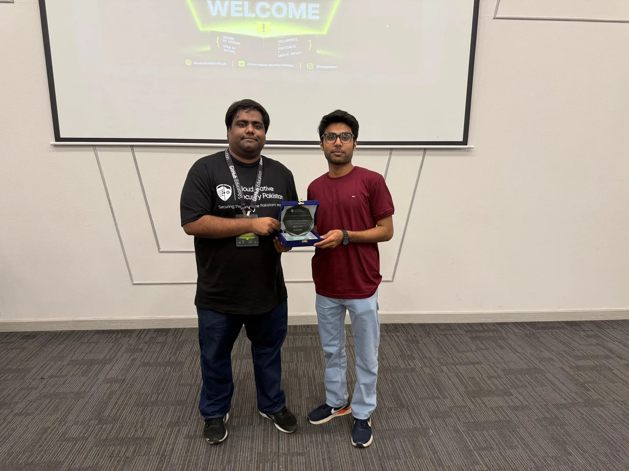 Mahad and a Cloud Native Security Pakistan organizer hold a speaker recognition plaque